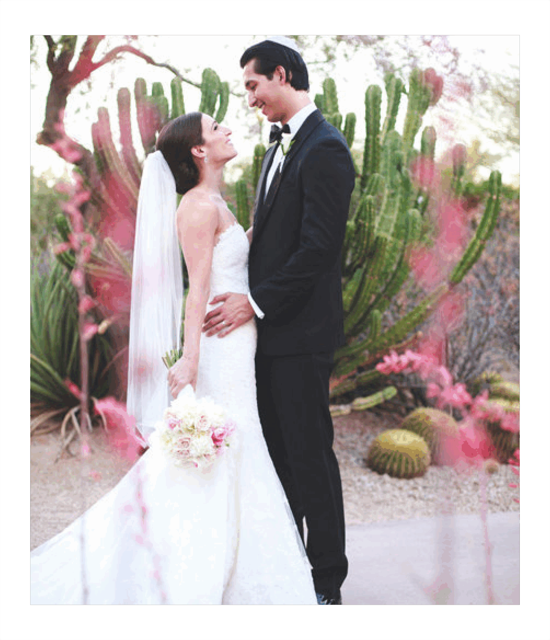 Bride and groom outdoors, surrounded by cacti.