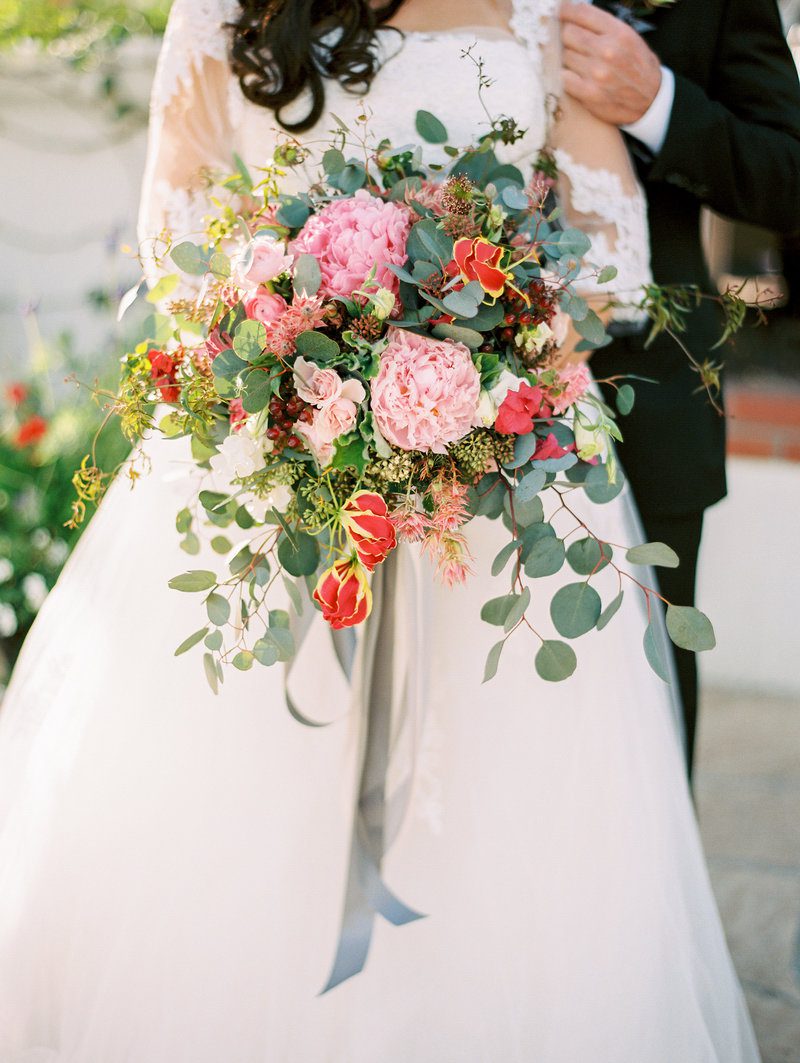 Bride holding vibrant, floral wedding bouquet.