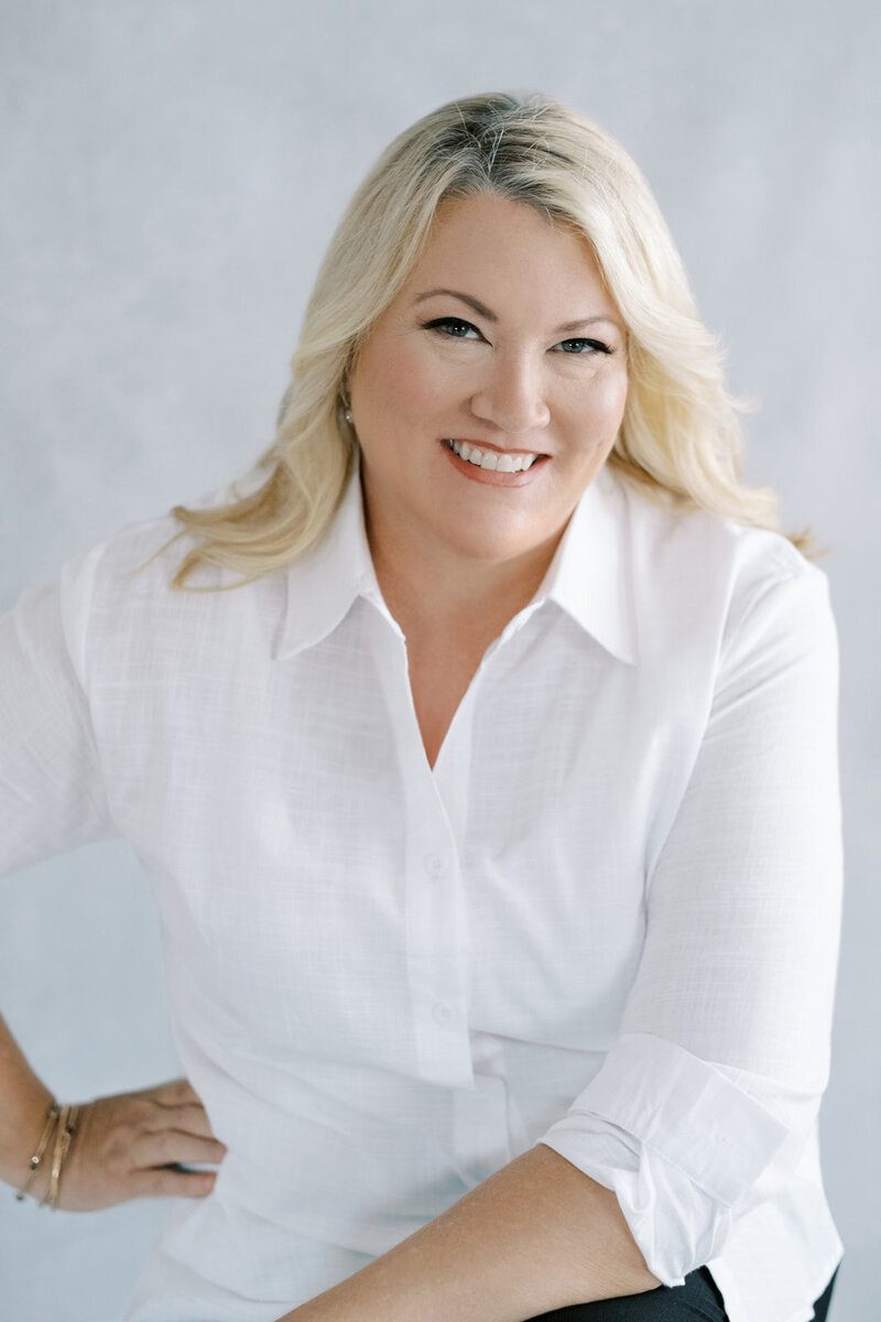 Smiling woman in a white shirt.