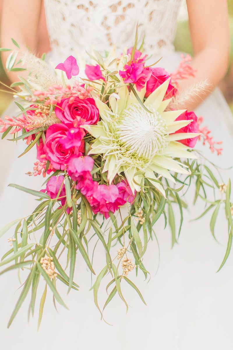 Bride holding vibrant pink and white bouquet.