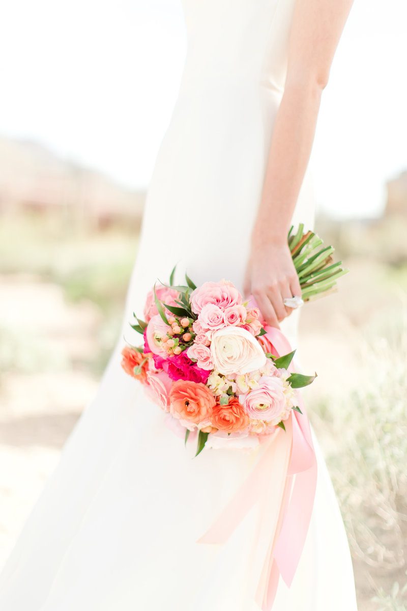 Bride holding colorful bouquet of flowers.