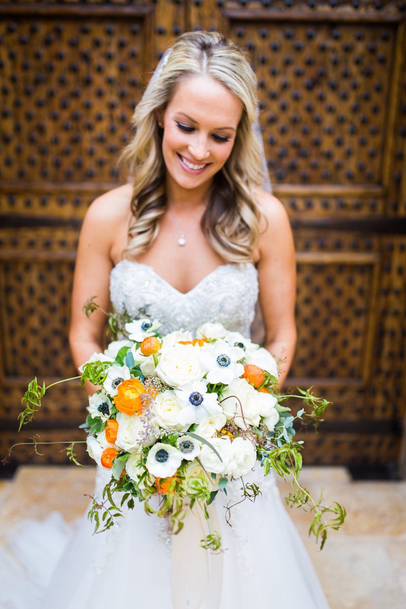 Bride holding bouquet in ornate setting.