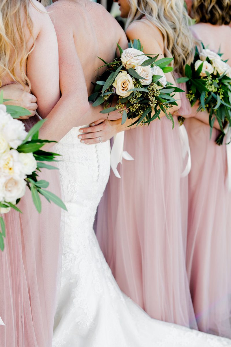Bridesmaids with bouquets in pink dresses.