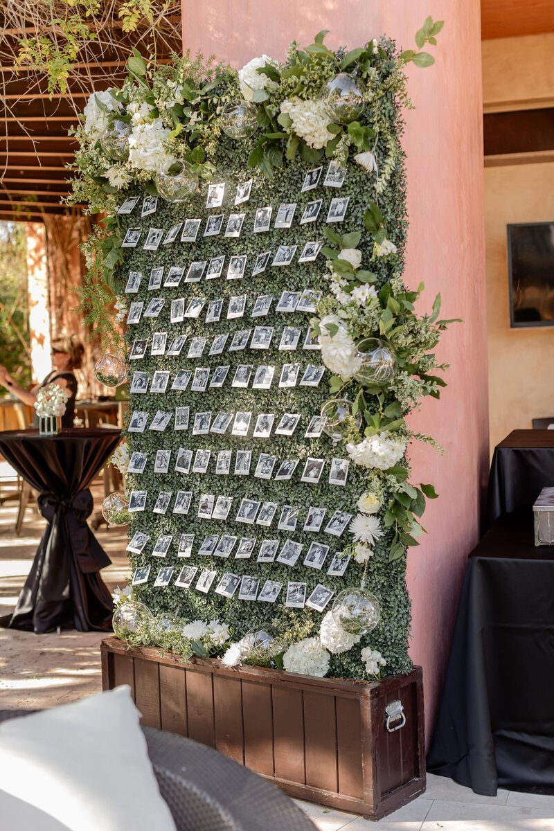 Floral seating chart display with photographs.
