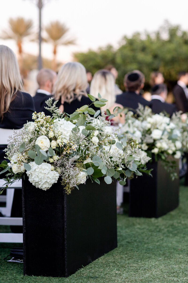 Outdoor wedding ceremony with floral arrangements.